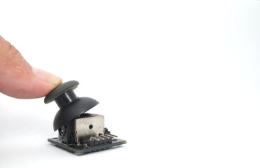 A joystick module with its rubber pad pressed by a thumb on a white background. Used for electronics and robotics enthusiasts.