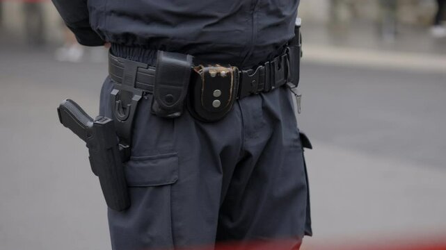 Policeman in uniform with special belt patrolling street. Equipment in form of pistol helps officer to quickly respond to emergency situations preventing negative consequences. Close up