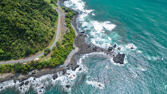Aerial shot of the coastline with turquoise sea and waves on a sunny day at Jaco viewpoint in Puntarenas, Costa Rica