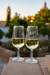 Sherry wine glasses and old bogedas jerez wine cellars and church on background in Jerez de la Frontera, wine glasses outdoor, cityview, Andalusia, Spain