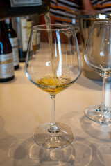 Tasting of sweet Bordeaux white wine in Sauternes, left bank of Gironde Estuary, France. Glasses of white sweet French wine served in restaurant