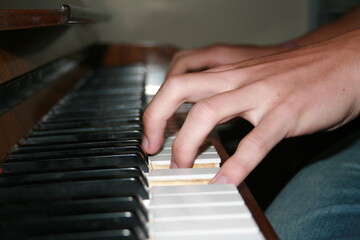 Fototapeta premium hands of a person playing piano close up