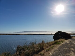 Bright Sun Over Calm River and Hills