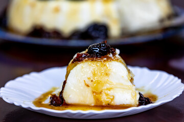 Traditional Brazilian coconut flan dessert known as manjar branco, manjar de coco and manjar dos deuses. Served with plum syrup.
