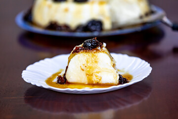 Traditional Brazilian coconut flan dessert known as manjar branco, manjar de coco and manjar dos deuses. Served with plum syrup.