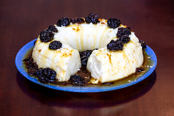 Traditional Brazilian coconut flan dessert known as manjar branco, manjar de coco and manjar dos deuses. Served with plum syrup.