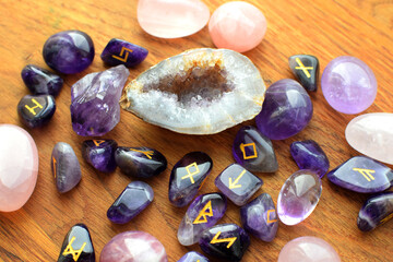 Amethyst and rose quartz crystals and Scandinavian runes on a wooden background. Predictions, witchcraft, spiritual esoteric practice.