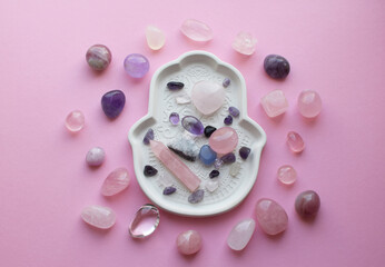 Pink healing chakras rose quartz and amethyst crystals. Stones are laid out on a plate. Real...