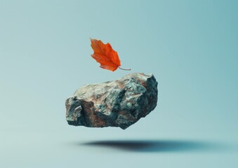 Floating rock with a single orange autumn leaf above it, creating an abstract and serene nature concept showcasing seasonal change.