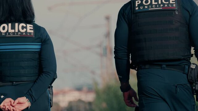 Two french police officers walking and patrolling the streets in Nice, France