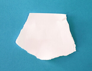 pieces of torn paper on blue background, copy space for your text.