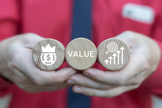 Business man holding wooden blocks sees word: VALUE. Increase value, growth value service, company value added, business growth concept. Value concept in business and finance.