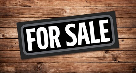 for sale lettering on card with wooden background