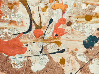 Abstract background of acrylic latex paint. Light brown, red, white and black spots of flowing splattered paint. Abstract expressionism.
