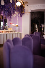 Interior of a cafe in purple colour with velvet purple furniture