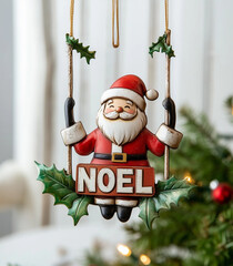 A cute Christmas-themed metal ornament featuring Santa Claus on a swing, holding the word "NOEL" in his hand.