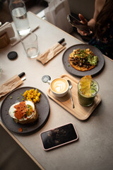 Breakfast with eggs and toasts, cappuccino coffee and iced matcha latte
