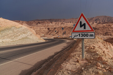 A view of the rocky and mountainous desert that is crossed by an asphalt road.
