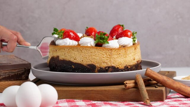 Mexican chocoflan, impossible cake, flan napolitano, a Mexican dessert with strawberries on top, Mexican woman cuts a slice of chocoflan with a spatula cake