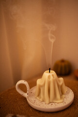 A candle has gone out. The smoke rises beautifully. Still life. Cozy atmosphere.