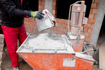 An automatic mixer for mixing dry plaster with water and automatically feeding the finished...