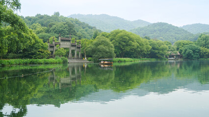 Maojiawu, located by the serene West Lake in Hangzhou, China. lush greenery, traditional Chinese architecture and forest, green trees and ancient buildings reflections in the water