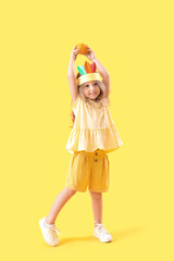 Cute little girl on yellow background. Thanksgiving Day celebration