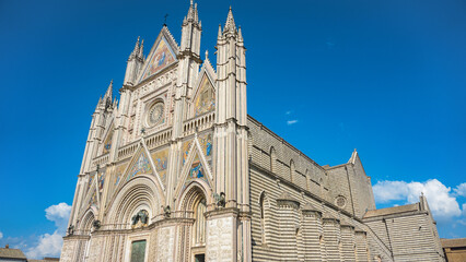 Obraz premium Orvieto, perched dramatically atop a volcanic tuff cliff in Umbria, Italy, is renowned for its stunning Gothic cathedral, ancient underground tunnels, and breathtaking views of the Italian countryside