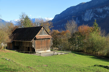 Old traditional wooden house in open air museum Ballenberg in autumn. View of the Alps. Municipality of Hofstetten bei Brienz, canton of Bern, Switzerland.