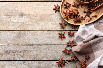 Composition with aromatic star anise, cloves and napkin on wooden background