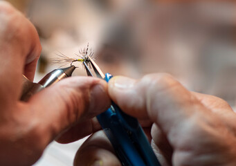 close up of a hands making a fishing fly