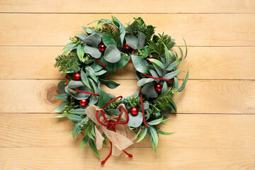 Beautiful Christmas mistletoe wreath on beige wooden background