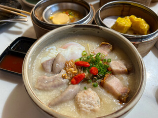 Hot Chinese congee (rice porridge) with minced pork ball and boiled egg as breakfast
