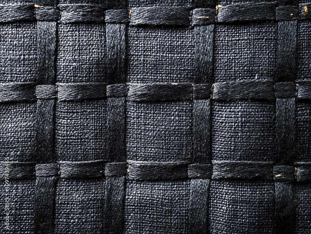 Poster a close-up of a textured black woven surface, showcasing intricate patterns and materials.