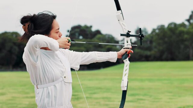 Archer, aim and girl with outdoor training, target practice and professional Japanese athlete. Bow, arrow and woman in sports challenge, shooting range and precision archery performance at kyudo club