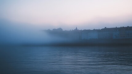 Fototapeta premium Enigmatic Fog-Shrouded Cityscape at Dawn Serene River and Historic Buildings in Misty Atmosphere
