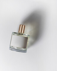 Perfume on white background with beautiful shadow, top view. Caustic, minimalism
