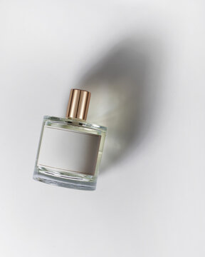 Perfume on white background with beautiful shadow, top view. Caustic, minimalism