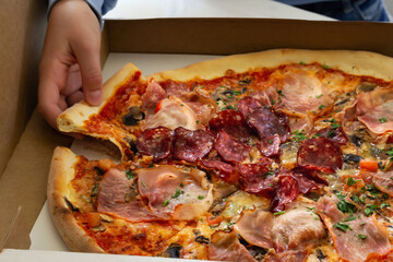Enjoying a delicious pizza with various toppings at home