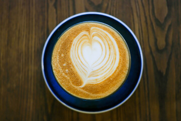Coffee art in a cup on wooden table