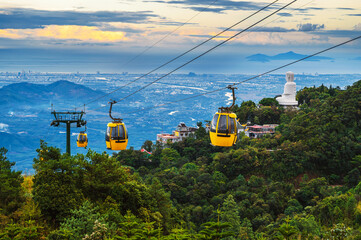 yellow cabanas of a funicular on a cable car in the mountains at the Ba Na Hills amusement park in...