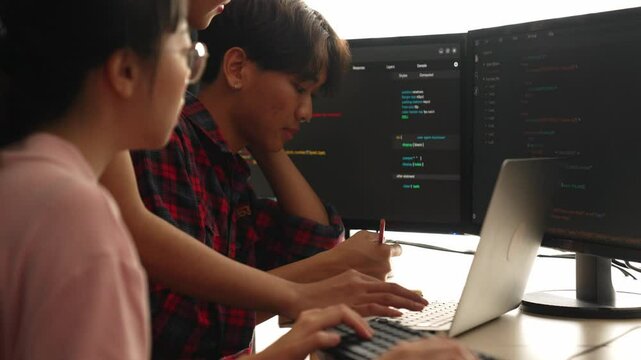 Slow motion back end software developer engineer for computer programming working together on debugging writing computing code, solving complex algorithms display on monitor in office. Burgeoning
