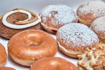 Assorted Donuts with Frosting, Glaze, and Powdered Sugar in a Close-Up View