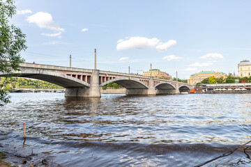 Fototapeta premium View from embankment of the Manes Bridge and opposite embankment on Vltava River in Prague in Czech Republic