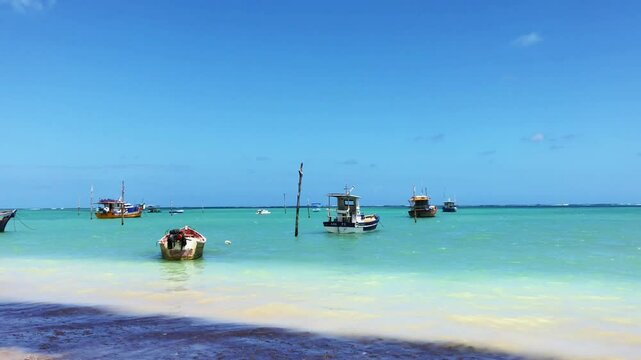 Peaceful scene of S&atilde;o Jos&eacute; da Coroa Grande, Pernambuco, Brazil, with turquoise waters,and boats anchored by the shore, creating a tropical setting perfect for moments of relaxation.