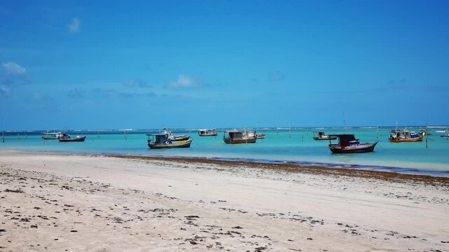 Charming view of S&atilde;o Jos&eacute; da Coroa Grande, Pernambuco, Brazil, with crystal-clear waters, golden sands, and colorful boats anchored. A tropical destination blending tranquility and unique beauty.