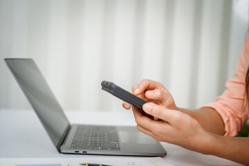 A close-up of a businesswoman working on a laptop in an office. As an accountant, she records financial data, verifies documents, manages income and expenses, ensuring accurate financial reporting