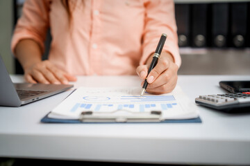 A close-up of a businesswoman working on a laptop in an office. As an accountant, she records financial data, verifies documents, manages income and expenses, ensuring accurate financial reporting