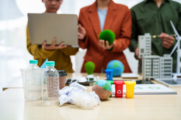 Asian business professionals discuss waste management and recycling strategies at desk, focusing on clean energy initiatives solar panels, electric cars, zero-waste solutions for sustainable future.