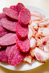 Sliced smoked sausage and bacon pieces close-up.